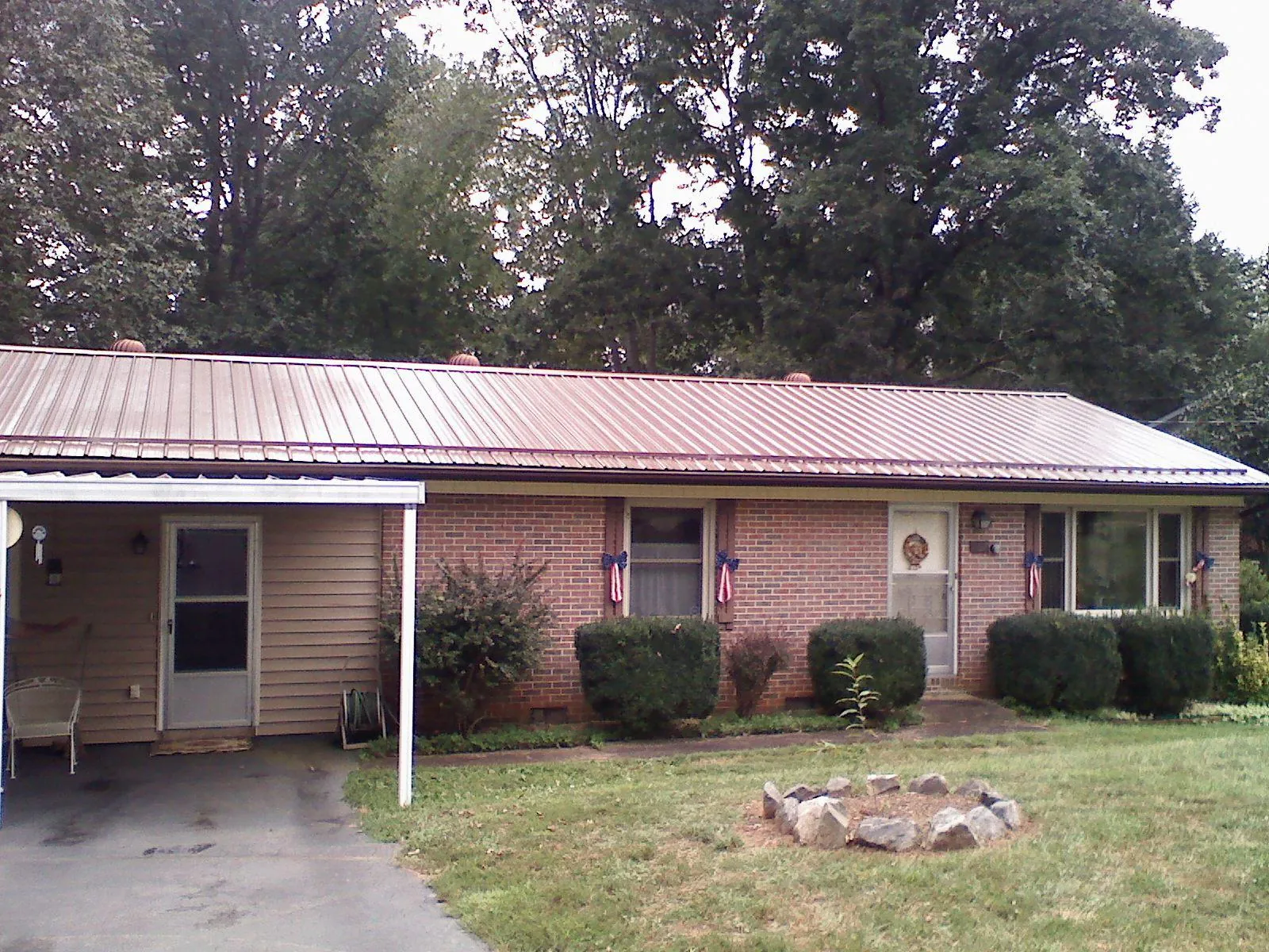 Bronze metal roof and carport on a brick ranch home — Roof Repair work by our crew in Collegeville